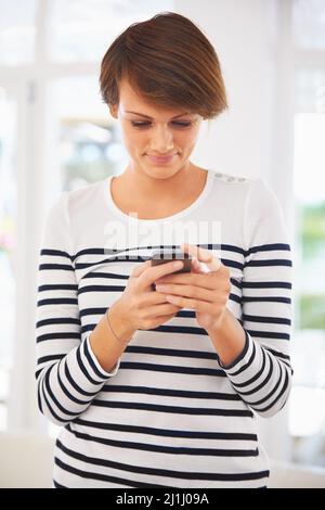 Aggiornamento stato... Partito al mio posto.... Vista frontale di una donna che usa il suo telefono. Foto Stock