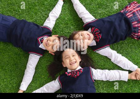 Gli allievi che giacciono sull'erba Foto Stock