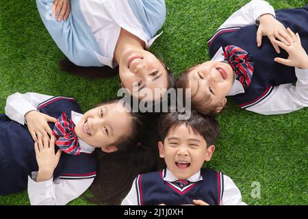 Gli allievi che giacciono sull'erba Foto Stock