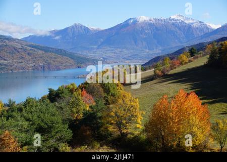 Coloratissimo fogliame a Serre Poncon, Alpi meridionali, Francia con il lago Foto Stock