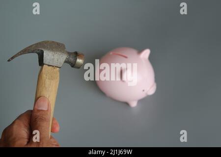 Mano che regge il martello per rompere il salvadanaio - un concetto  finanziario Foto stock - Alamy