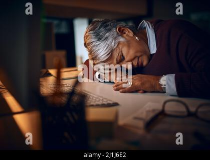 Ho solo bisogno di un rapido snooze.... Shot di una donna d'affari matura che dorme alla sua scrivania mentre lavora tardi in un ufficio. Foto Stock