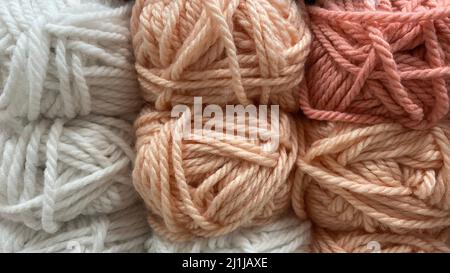 gamma di filati di lana beige, rosa e bianco. Matasse multicolore di lana primo piano Foto Stock