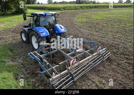 Germania, New Holland Tractor T6,180 con motore a gas alimentato da gas di biometano CNG, che opera sul campo preperazione del suolo / DEUTSCHLAND, Damnatz im Wendland, neuer New Holland Traktor T6,180 mit Methanpower mit Gasmotor und Biomethan bzw. Gas CNG Antrieb im Test beim Grubbern auf dem Acker Foto Stock