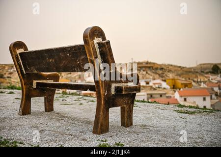 Isolata vecchia panca con vista sul villaggio rurale. Foto Stock