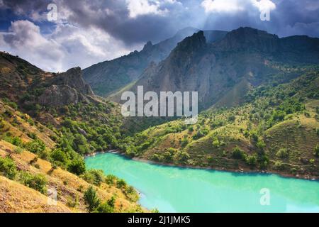 Maestoso paesaggio montano su un lago tranquillo. Nuvole di tempesta Foto Stock