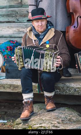 Rumsiskes, Lituania - Febbraio 26 2022: Musicista tradizionale che suona fisarmonica a Rumsiskes, Lituania durante Uzgavenes, un festival folk lituano Foto Stock