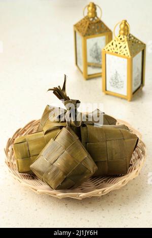 Ketupat (in Indonesiano e Malese), kupat (in Giavanese e Sundanese) o tipat (in Balinese) è una torta di riso giavanese confezionata all'interno di un condizionatore a forma di diamante Foto Stock