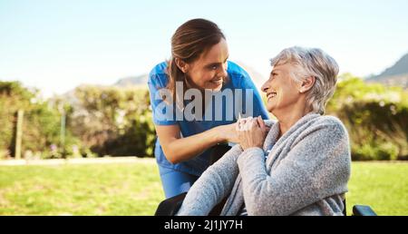 Una certa vitamina D è appena che cosa avete bisogno oggi. Scatto corto di una giovane infermiera femminile all'esterno con un paziente anziano in sedia a rotelle. Foto Stock