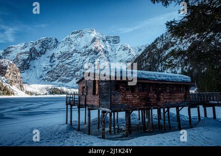 La baracca di legno su palafitte utilizzata in estate per il noleggio di barche sul lago di Braies, chiusa in inverno Foto Stock
