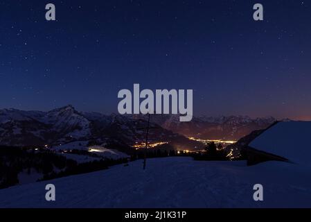 Cielo stellato le vette innevate delle Alpi Glaronesi in Svizzera illuminano all'alba d'inverno Foto Stock