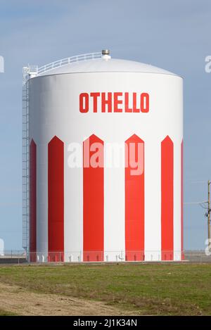 Othello, WA, USA - 24 marzo 2022; torre dell'acqua dipinta di rosso e bianco con il nome della città di Othello nel centro dello stato di Washitngton nella comunità rurale Foto Stock