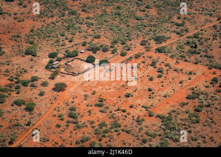 Vista aerea di pascolo bestiame e un recinto fattoria tribù Maasai e casa di famiglia nella sere savana del Kenya Foto Stock