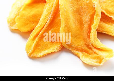 Fette di frutta di mango dolci essiccate come sfondo arancione textural a schermo intero Foto Stock