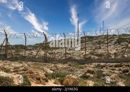 Base militare con recinzione spinato e antenne. Foto Stock