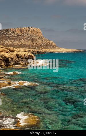 Seascape Cape Greco Peninsula Park, Cipro. E' una penisola montagnosa con un parco nazionale, sentieri di roccia, una laguna turchese e un ponte di pietra naturale Foto Stock