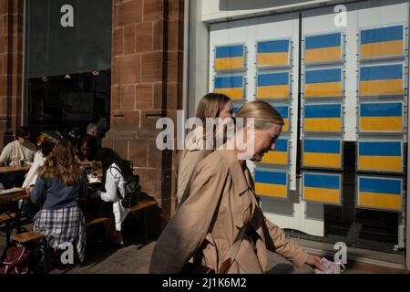 Glasgow, Regno Unito. 26th marzo 2022. La finestra agente immobiliare visualizza la bandiera ucraina blu e gialla invece degli elenchi di proprietà della casa, a sostegno dell'Ucraina nella loro attuale guerra con il presidente PutinÕs Russia, nella zona di Merchant City di Glasgow, Regno Unito. 26 marzo 2022. Photo credit: Jeremy Sutton-Hibbert/ Alamy Live News. Foto Stock