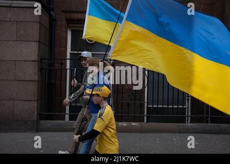 Glasgow, Scozia, 26th marzo 2022. Una famiglia Ucraina, con bandiere blu e gialle ucraine, si recheranno a George Square per il raduno Stand with Ukraine a sostegno del loro paese nella sua attuale guerra contro l'invasione del presidente PutinÕs Russia, a Glasgow, Scozia, 26 marzo 2022. Photo credit: Jeremy Sutton-Hibbert/Alamy Live News. Foto Stock