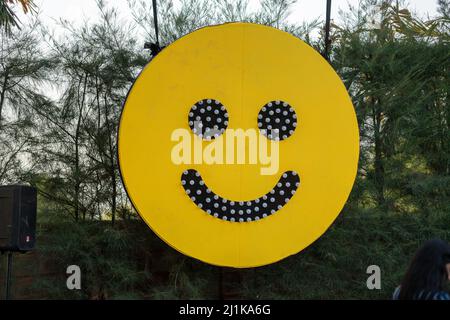 Una bandiera sorridente nel parco con un volto fatto di perle. Foto Stock