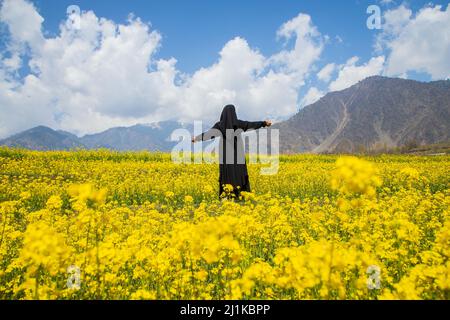 Srinagar, India. 24th Mar 2022. Una ragazza di Kashmiri si pone per una foto in un campo di senape in una soleggiata giornata di primavera nella periferia di Srinagar. Senape e mandorla sono importanti colture in contanti nella valle. Mentre il sole luminoso bagna la regione dopo un inverno duro e tetro, cieli blu e clima allegro approccio e nuove fioriture come mandorle, pesche, pere, ciliegie e i fiori di senape giallo brillante dipingono una sommossa di colori sulla tela della natura, dare freschezza all'aria e una fragranza dolce ''' che segnala l'arrivo della primavera. (Credit Image: © Faisal Bashir/SOPA Images via ZUMA Press Wire) Foto Stock