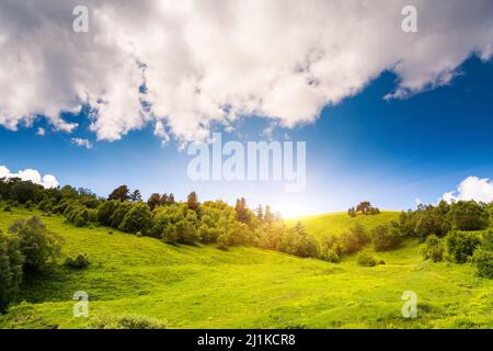 Splendida vista sul paesaggio rurale alpino. Colline soleggiate sotto il cielo nuvoloso. Upper Svaneti, Georgia, Europa. Montagne del Caucaso. Mondo di bellezza. Foto Stock