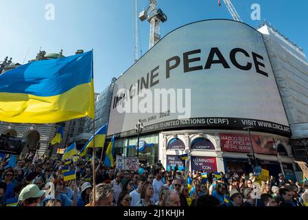 Londra, Regno Unito. 26 marzo 2022. La gente partecipa a “Londra sta con l’Ucraina”, una marcia di solidarietà, passando per Piccadilly Circus, dove viene visualizzato il messaggio “IMAGINE PEACE” di Yoko Ono, ad una veglia in Trafalgar Square. Il presidente ucraino Volodymyr Zelensky ha lanciato un appello a persone di tutto il mondo affinché si portino in piazza per dimostrare sostegno all'Ucraina per segnare un mese dell'invasione russa. Credit: Stephen Chung / Alamy Live News Foto Stock