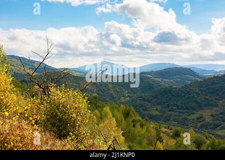 paesaggio di campagna carpaziana all'inizio dell'autunno. bellissimo paesaggio di montagna con luce appollata. caldo giorno di sole con nuvole sul cielo Foto Stock