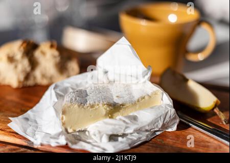 Un primo piano di formaggio camembert sul tagliere di legno Foto Stock