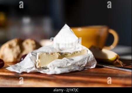 Un primo piano di formaggio camembert sul tagliere di legno Foto Stock