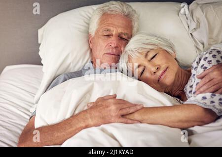 Momenti come questo sono inestimabili. Shot di una coppia anziana che dorme a letto. Foto Stock