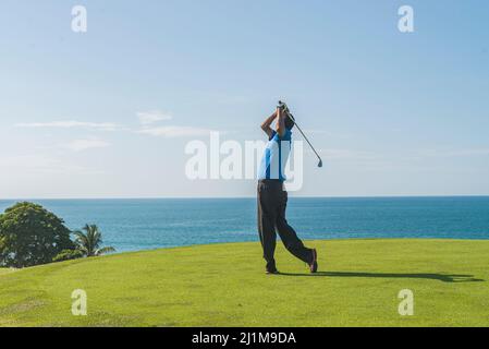 Istruttore di golf latino che pratica il suo swing Foto Stock