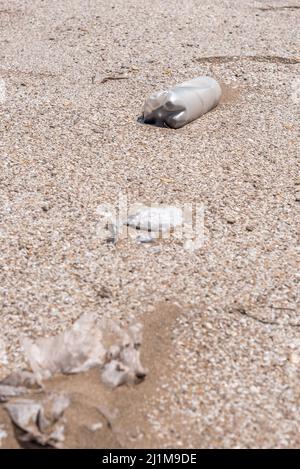 Bottiglia di plastica adagiata sulla sabbia vicino alla spiaggia. Prendiamo cura del pianeta Foto Stock