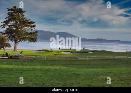 I giocatori affrontano il green 18th sul famoso campo da golf Pebble Beach Golf Links a Pebble Beach, California, USA Foto Stock