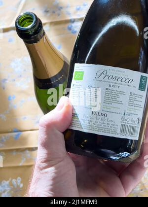 Parigi, Francia - 3 gennaio 2022: Bottiglia a mano POV maschio con spumante biologico Bio Prosecco - prodotto da Valdoz Foto Stock