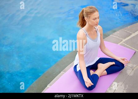 Nessun pocus hocus solo la messa a fuoco. Shot di una giovane donna che fa yoga all'aperto. Foto Stock