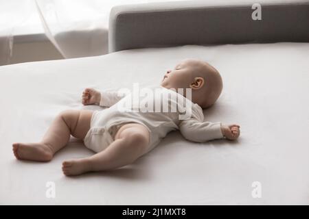 Tranquillo adorabile bambino neonato che dorme sul divano. Foto Stock