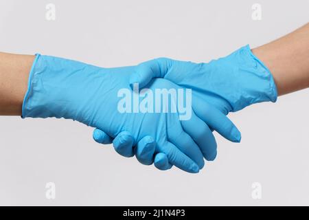 Le persone che indossano guanti in lattice si salutano a vicenda Foto Stock