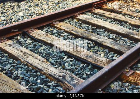 Primo piano di binari ferroviari, binari in acciaio e traversine in legno Foto Stock