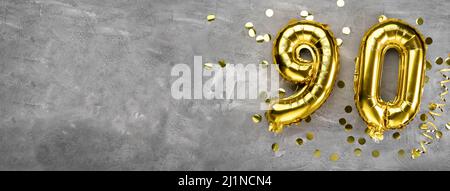 Numero palloncino in foglio giallo, numero novanta su sfondo concreto. Biglietto d'auguri con l'iscrizione 90. Concetto di anniversario. Per anniversario Foto Stock