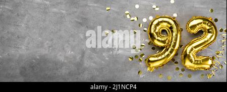 Palloncino di alluminio giallo numero novantadue su sfondo concreto. Biglietto d'auguri con l'iscrizione 92. Concetto di anniversario. Per anniversario, compleanno Foto Stock