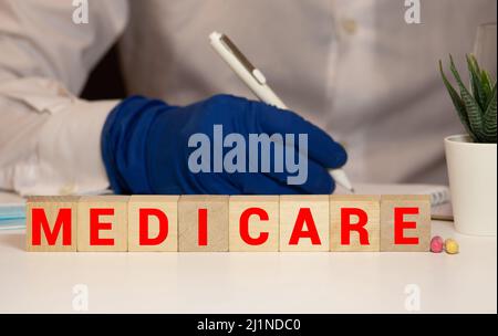 Medicare parola scritta sul blocco di legno. medicare testo sul tavolo, concetto. Foto Stock