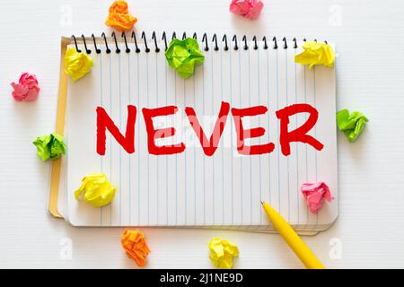 Mai. Pezzi di carta strappati con le parole mai. Concetto di immagine. In bianco e nero. Close up. Foto Stock