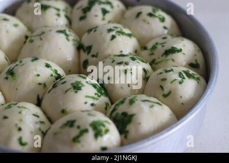 La pasta per la cena è pronta per andare al forno preparato in una teglia circolare. Glassato con burro, coriandolo tritato ed erbe. Sparato sul backgroud bianco Foto Stock