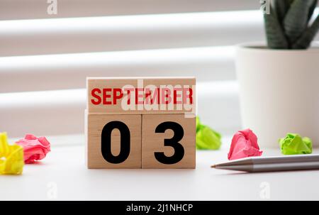 Settembre 3. Data del mese di settembre. Cubo di numero con un fiore e legno segno su tavolo di legno Diamante per lo sfondo. Foto Stock
