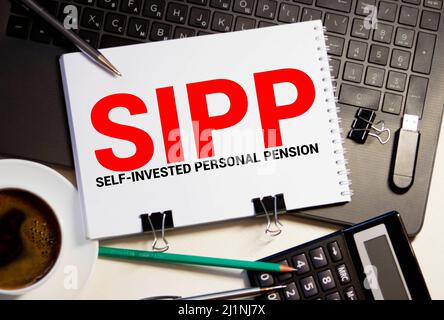 Carta con Self-invested Personal Pension SIPP su un tavolo con carta, penna e lente di ingrandimento Foto Stock