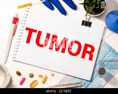 Il medico conserva una scheda con il nome della diagnosi - tumore. Messa a fuoco selettiva. Concetto medico. Foto Stock