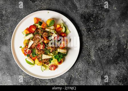 Insalata di bistecca con verdure alla griglia e formaggio. Pranzo o cena deliziosi e sani in estate. Carne di manzo con senape bavarese dolce. Vista dall'alto. Foto Stock