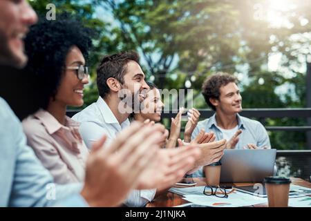Grandi cose continueranno ad emergere per loro. Foto di un gruppo di colleghi che hanno applaudato durante una riunione in un bar. Foto Stock