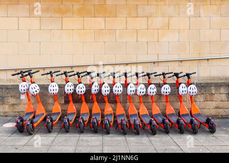 Orange neurone mobilità e scooter a noleggio parcheggiati in una fila a Newcastle su Tyne, Regno Unito Foto Stock