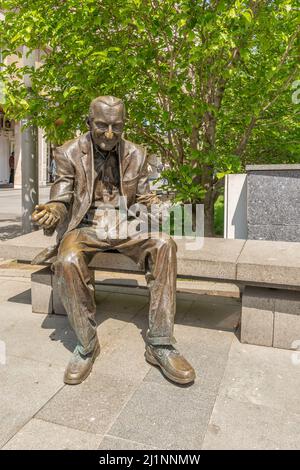 Antica statua di un uomo che alimenta piccioni seduti su una panchina, centro storico di Craiova, Romania Foto Stock